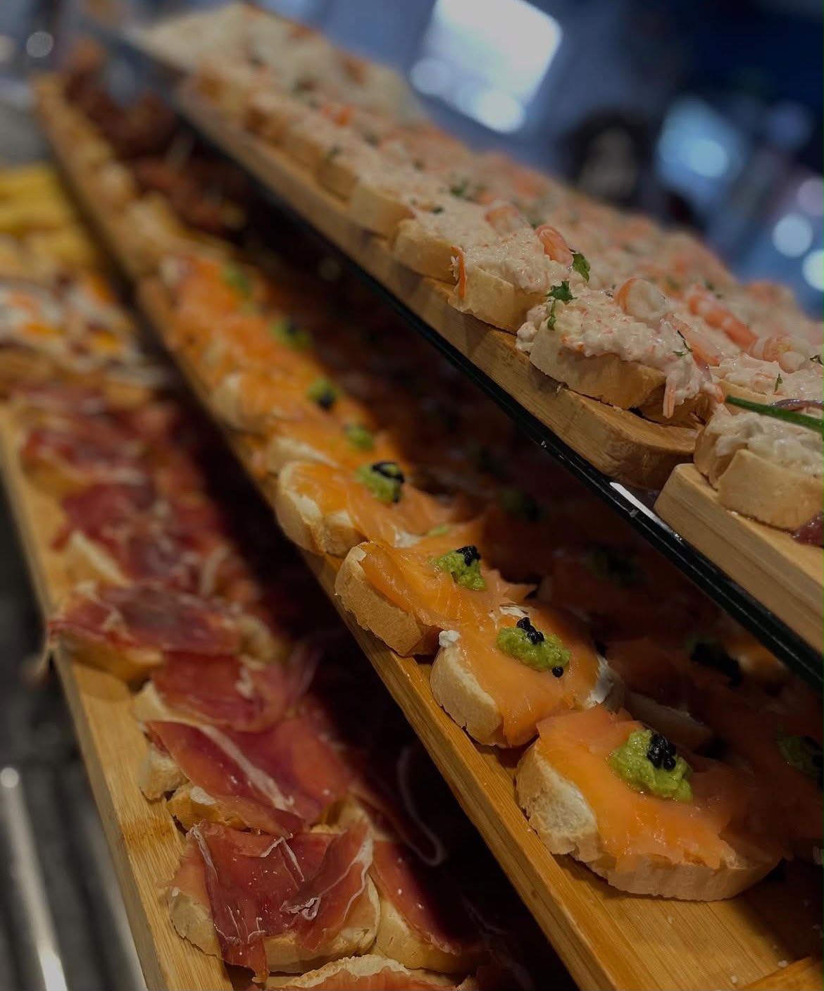 Expositor de pinchos de jamón, salmón y gambas